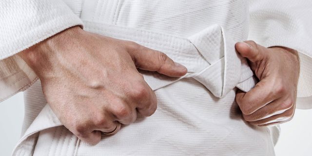 Feature-Bild für den Ju-Jitsu Verband Sachsen-Anhalt. Nahaufnahme von zwei Händen und einem weißen Gürtel.
