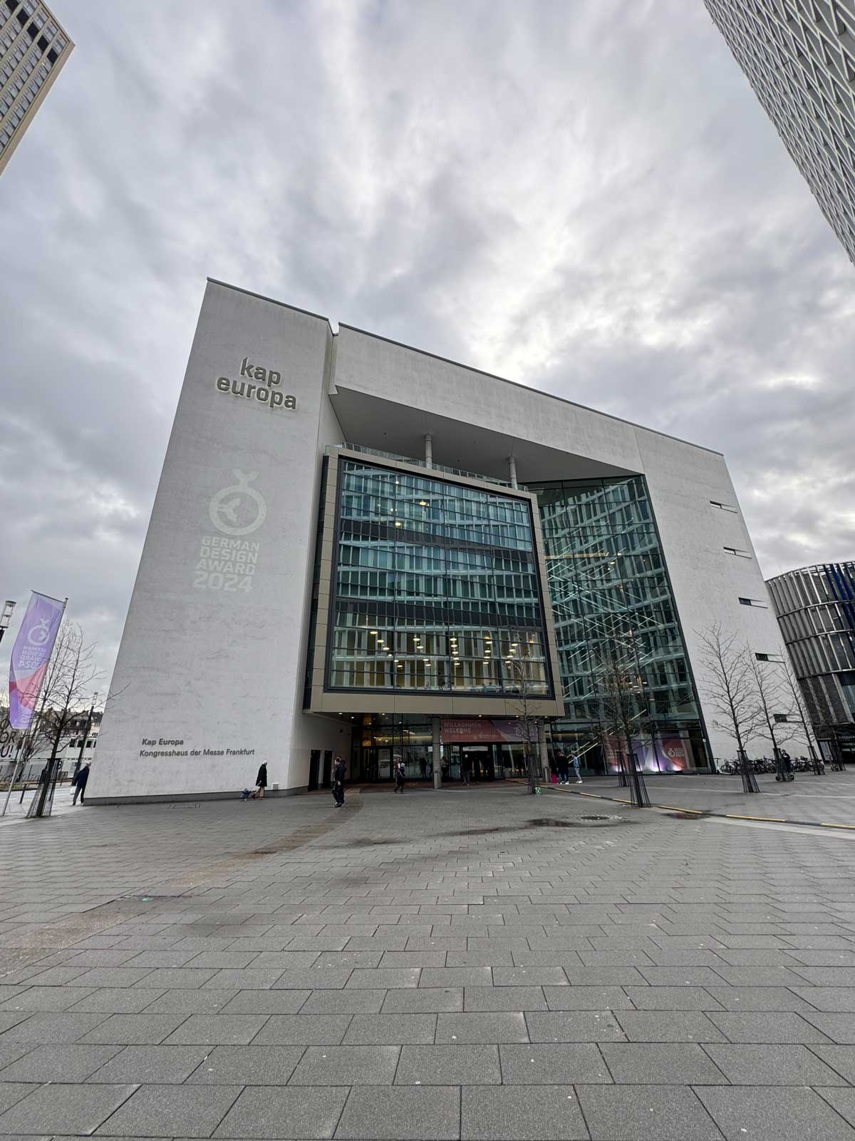 Außenansicht des Kap Europa, Kongresshaus der Messe Frankfurt. Das Logo des German Design Award 2024 ist auf die linke Seite der Fassade projiziert.
