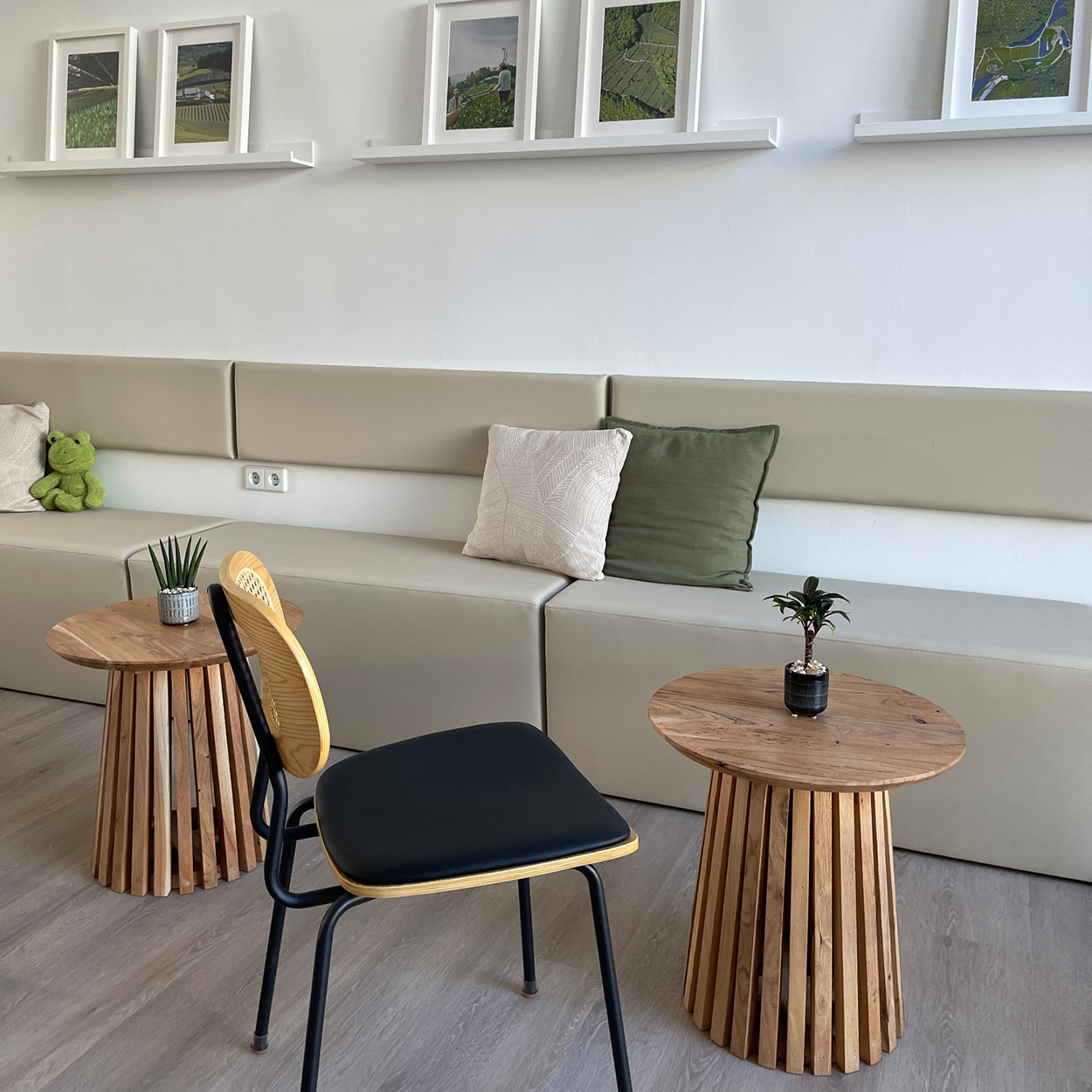 Sitzbereich im Teehaus der iūgen GmbH in Halle (Saale) mit Holztischen und minimalistischer Innenausstattung